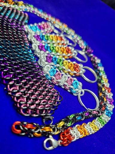 An assortment of necklaces, bracelets, and keychains in various Pride flag colors.